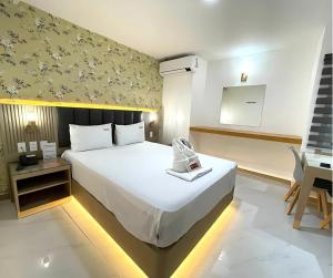 a bedroom with a large white bed and a desk at Maganda Hotel - San Fernando in San Fernando