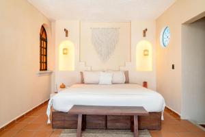 ein Schlafzimmer mit einem großen weißen Bett in einem Zimmer in der Unterkunft Mezcal Boutique Hotel in Cancún