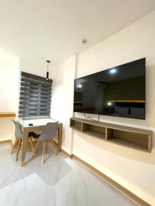 a dining room with a table and a large tv on the wall at Maganda Hotel - San Fernando in San Fernando