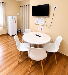 a room with a table and chairs and a refrigerator at Ondas do Preá - 700m da Praia - 12 km de Jeri in Prea