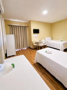 a hotel room with two beds and a tv at Ondas do Preá - 700m da Praia - 12 km de Jeri in Prea