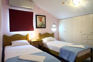 a bedroom with two beds and a table with a mirror at Liogerma Villas in Agios Nikitas +15 photos