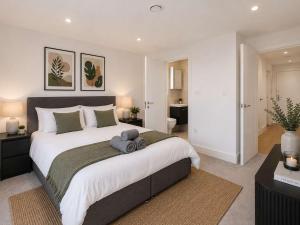 a bedroom with a large bed and a bathroom at 2 Bedroom Addenbrookes Apartment in Trumpington