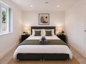 a bedroom with a large bed with two lamps at 2 Bedroom Addenbrookes Apartment in Trumpington
