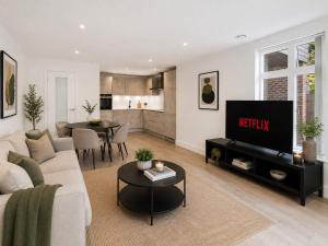 a living room with a couch and a tv at 2 Bedroom Addenbrookes Apartment in Trumpington