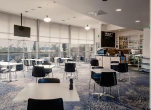 a room with tables and chairs in a library at Mantra Hobart Airport in Hobart