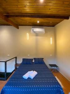 a bedroom with a blue bed with two towels on it at Casa no Centro de São Francisco Xavier in São José dos Campos