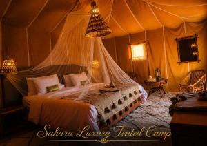 a bedroom with a bed in a tent at Sahara Luxury Tented Camp in Merzouga