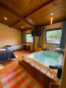 a room with a tub in the middle of a bedroom at Casa no Centro de São Francisco Xavier in São José dos Campos