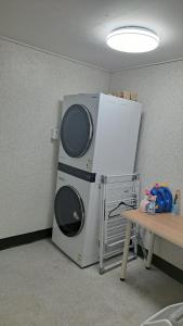 a refrigerator with two microwaves sitting next to a table at Lakestone&Hotel Sokcho in Sokcho
