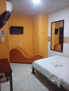 a bedroom with a bed and a mirror and a couch at Hotel capital in Florencia