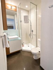 a bathroom with a shower sink and a toilet at Union Centre Hotel & Suites in Toronto