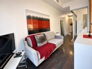 a living room with a couch with a red blanket at Union Centre Hotel & Suites in Toronto