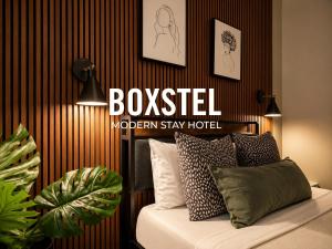 a bedroom with a bed and a sign that reads boosted modern stay hotel at Boxstel - Modern Stay Hotel Downtown El Paso in El Paso