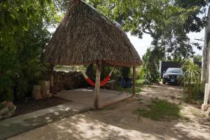 a person is laying in a thatch hut at Pequeño Refugio in Ticul