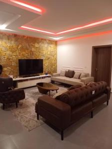 a living room with a couch and a tv at Woodloft in Lagos