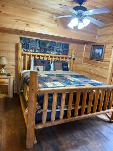 a bedroom with a wooden bed with a ceiling fan at Bear Loads of Fun in Sevierville