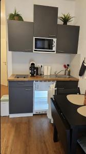 a kitchen with a stove and a microwave at Imperial Baths Boutique Studio in Trier