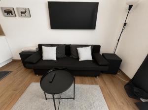 a living room with a black couch and a chair at Imperial Baths Boutique Studio in Trier