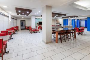 a dining room with tables and red chairs at Holiday Inn Express & Suites - Laredo-Event Center Area by IHG in Laredo