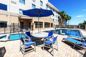 a table with chairs and an umbrella next to a pool at Holiday Inn Express & Suites - Laredo-Event Center Area by IHG in Laredo