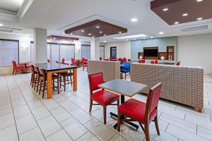 a dining room with tables and red chairs at Holiday Inn Express & Suites - Laredo-Event Center Area by IHG in Laredo