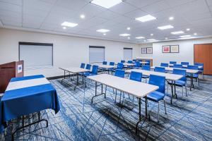 an empty classroom with tables and blue chairs at Holiday Inn Express & Suites - Laredo-Event Center Area by IHG in Laredo