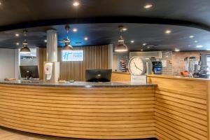 a bar in a restaurant with a clock on the wall at Holiday Inn Express Liverpool-Albert Dock by IHG in Liverpool