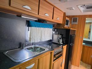 a kitchen with a sink and a stove at Luxury Caravan at 10 in Oakleigh