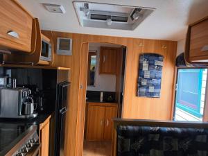 a kitchen with wooden cabinets and a stove top oven at Luxury Caravan at 10 in Oakleigh