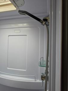 a shower in a bathroom next to a door at Luxury Caravan at 10 in Oakleigh