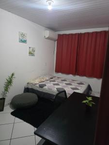 a small room with a bed and a table at Pousada de Isa in Palhoça
