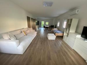 a living room with a white couch and a table at Kuća za odmor Aranđelovac in Arandelovac