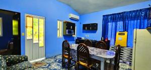 a kitchen with blue walls and a table and chairs at Casa de Descanso - Camelia in Monte Gordo +8 photos