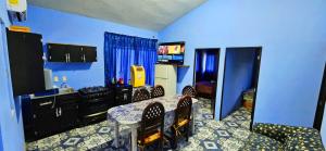 a kitchen with blue walls and a table and chairs at Casa de Descanso - Camelia in Monte Gordo