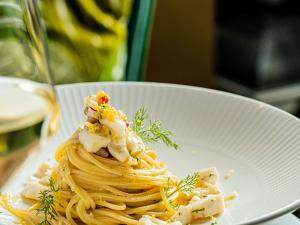 a white bowl of pasta with shrimp on top at Hotel Mercure Roma Corso Trieste in Rome