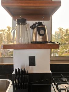 a counter with two coffee makers on top of a stove at Condominio Agave del Mar in Coyuca