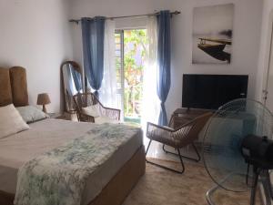a bedroom with a bed and a tv and a window at Casa Kriolu in Praia