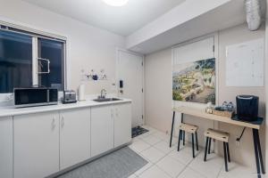 a kitchen with white cabinets and a sink at Bright Maple Suite in Richmond