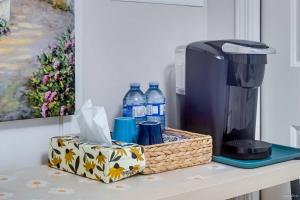 a basket with a coffee maker and water bottles on a counter at Bright Maple Suite in Richmond