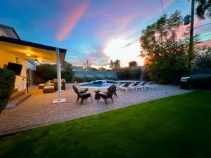 a patio with chairs and a pool at sunset at Casa Gia- Quiet Luxury Biltmore Area - Heated Pool in Phoenix