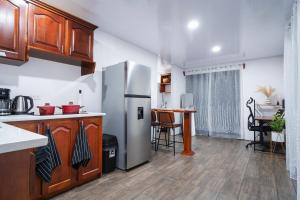 a kitchen with a stainless steel refrigerator and a table at Arenal Pecpen in Fortuna