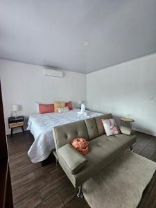 a bedroom with a bed and a couch at Arenal Pecpen in Fortuna