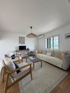 a living room with a couch and a table at Hydrangea House in Água de Pau