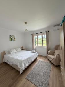 a white bedroom with a bed and a couch at Hydrangea House in Água de Pau