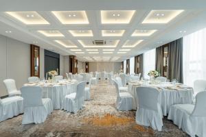 a banquet hall with white tables and white chairs at Holiday Inn Ulaanbaatar by IHG in Ulaanbaatar