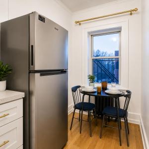 a kitchen with a refrigerator and a table with chairs at High Falls Studio TV Kitchen Downtown Rochester in Rochester