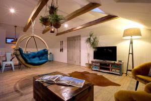 a living room with a couch and a tv and a table at Bohemian Chic 2 Bedroom 2 Bathroom Loft with Hanging Chair in Prague