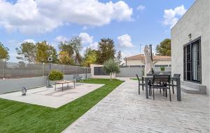 a patio with a table and chairs and grass at Villa Villaplana in Fortuna