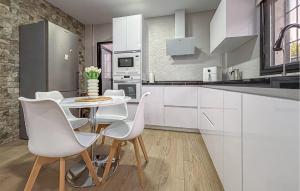 a kitchen with white cabinets and a white table and chairs at Villa Villaplana in Fortuna